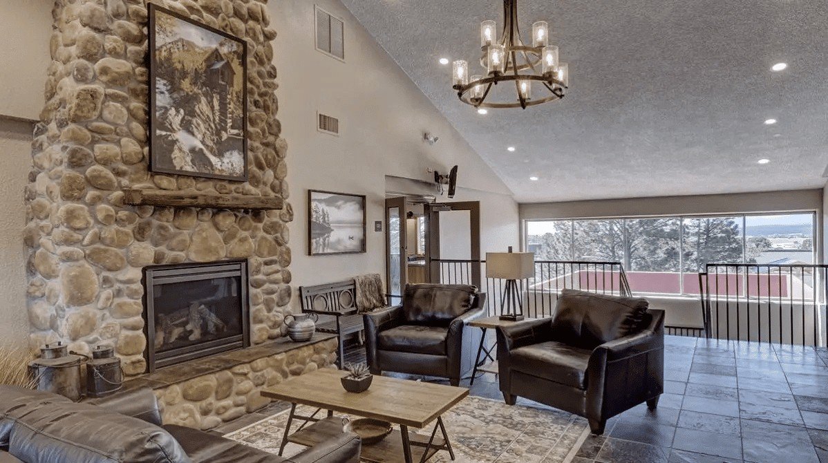 Mountain Springs Recovery shared lounge with comfortable seating and a stone fireplace