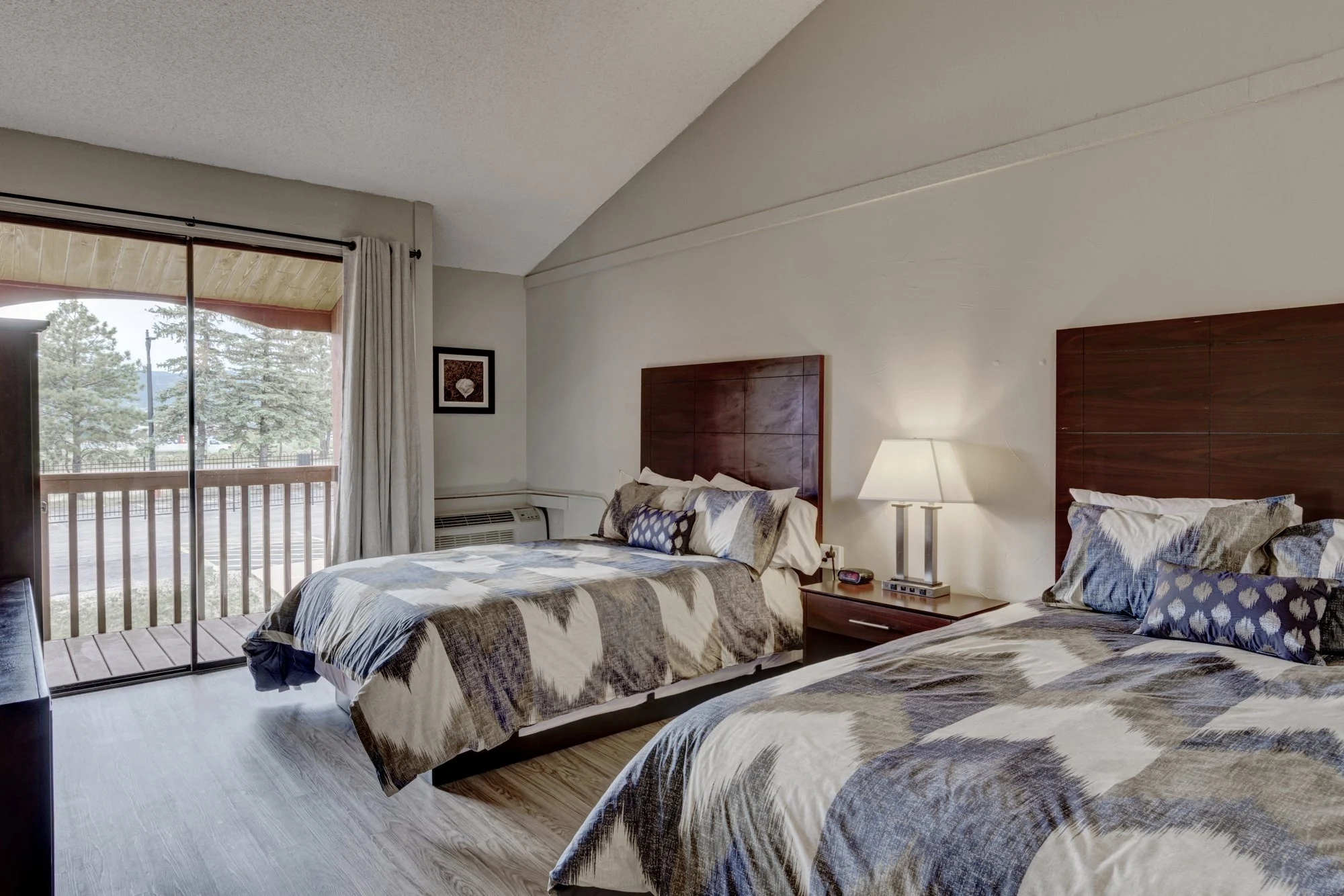 Semi-private bedroom with two beds and a balcony at Mountain Springs Recovery